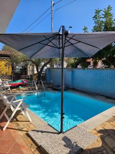 a white umbrella sitting next to a swimming pool at Da Anna Casa Vacanza Al Mare in Santa Lucia