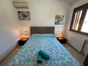 a bedroom with a bed with blue sheets and two lamps at Da Anna Casa Vacanza Al Mare in Santa Lucia