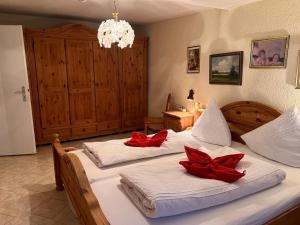 two beds in a bedroom with red bows on them at seeglueck Retro Am Münster in Konstanz