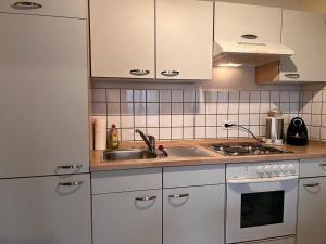 a kitchen with white cabinets and a sink at seeglueck Retro Am Münster in Konstanz