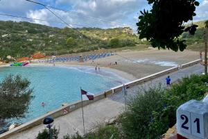 a beach with a bunch of people in the water at Beachfront Apartment in Calan Porter Menorca in Cala en Porter