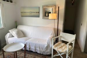 a living room with a couch and a table at Beachfront Apartment in Calan Porter Menorca in Cala en Porter +14 photos