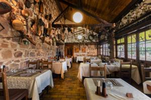 a restaurant with white tables and chairs and windows at Logis Hôtel LE DAHU in Parigny