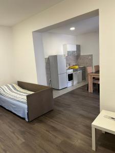 a room with a bed and a kitchen at Apartmani Centar in Sivac