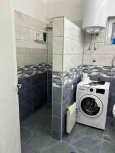 a bathroom with a washer and a washing machine at Apartmani Centar in Sivac