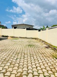a brick road in front of a white fence at Bulle d'Or Classique in Libreville