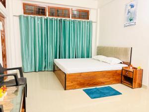 a bedroom with a bed and a green curtain at Kalm Homestay in Dispur
