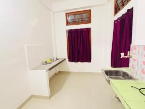 a bathroom with red curtains and a sink at Kalm Homestay in Dispur