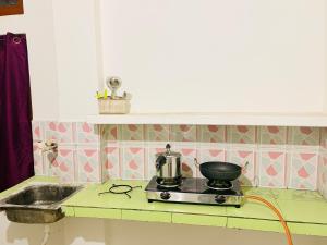a kitchen counter with a pot on a stove at Kalm Homestay in Dispur