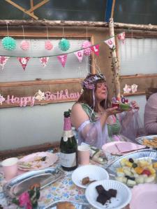 a woman is sitting at a table with food at EcoPod Holidays in Alton