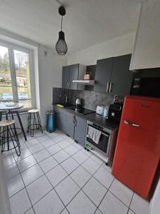 a kitchen with a red refrigerator and a table at F2 avec jardin in Nemours
