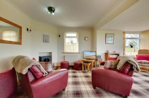 a living room with two red couches and a tv at Brackenrigg Embleton in Embleton