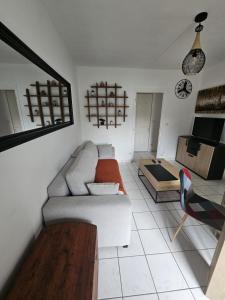 a living room with a couch and a table at F2 avec jardin in Nemours