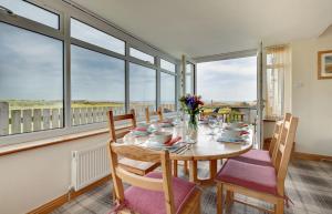 a dining room with a table and chairs and windows at Brackenrigg Embleton in Embleton