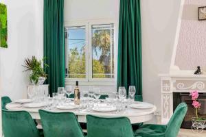 a dining room with a table and green chairs at Villa Mika in Zakynthos