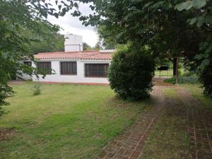 a white building with a brick path in a yard at Casa Canela in La Cumbre +20 photos