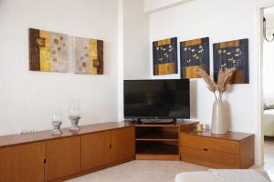 a living room with a television on a wooden entertainment center at Mola's Memories in Mola Kalyva