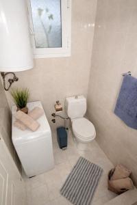 a bathroom with a toilet and a sink and a window at Mola's Memories in Mola Kalyva