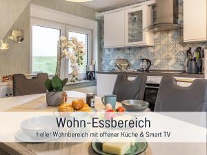 a kitchen with a table with a plate of food on it at Ferienwohnung KIEK RUT - Gartenstrand, Wallbox & Sauna, alles für die Familie, zusätzlicher Loft in Harlesiel in Wittmund