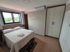 a bedroom with a bed and a large window at Hotel Canta Galo Tower in Jacarèzinho +4 photos