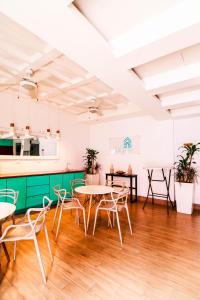 a room with tables and chairs and a kitchen at Hotel Casa Turquesa in Flores