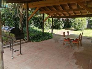 a patio with a grill and a table and chairs at Casa Canela in La Cumbre