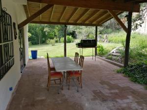 a patio with a table and chairs and a grill at Casa Canela in La Cumbre