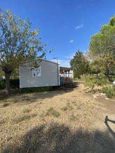 a small white building with a porch and a tree at mon paradis in Lattes +3 photos