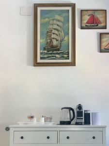 a painting of a ship on a wall above a dresser at EvasRooms Open space in Vernazza