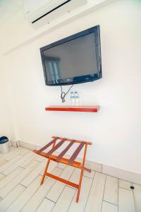 a wooden stool with a flat screen tv on a wall at Hotel Casa Turquesa in Flores