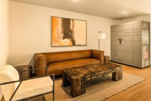 a living room with a brown couch and a table at LivAway Suites Phoenix Tolleson in Phoenix