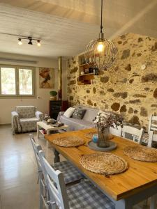 a dining room and living room with a table and chairs at DOLONAS Cosy House in Aliyoí