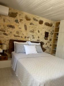 a bedroom with a bed with white pillows at DOLONAS Cosy House in Aliyoí