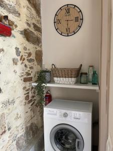 a washing machine in a bathroom with a clock on the wall at DOLONAS Cosy House in Aliyoí