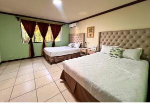 a bedroom with two beds in a room with green walls at Villa Noelia in El Jurón +70 photos