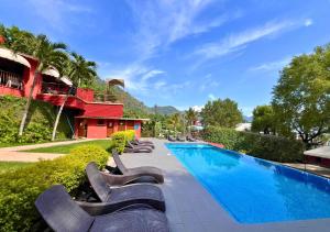 a swimming pool with lounge chairs next to a building at Villa Noelia in El Jurón