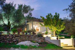 a home with a stone retaining wall and trees at DOLONAS Cosy House in Aliyoí