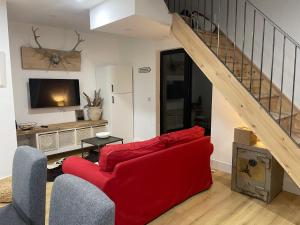 a living room with a red couch and a staircase at Cosy nap under the Paps in Killarney