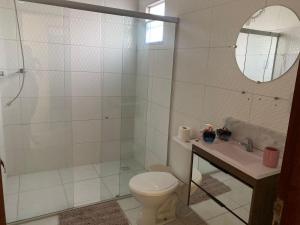 a bathroom with a toilet and a sink and a mirror at Suíte prime in Monte das Gameleiras