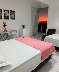 a bedroom with two beds and a table and chairs at Suíte prime in Monte das Gameleiras