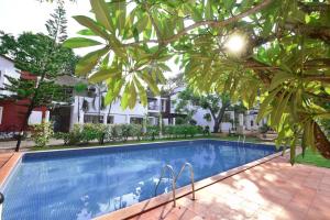 a pool in front of a house with trees at Azure Luxury 3-Bedroom Penthouse Candolim, Next to Novotel and Starbucks, close to Beach - By Lembranca in Candolim