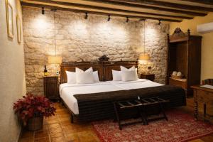 a bedroom with a large bed and a stone wall at Posada Mayor de Migueloa in Laguardia +75 photos