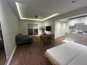 a living room with a bed and a kitchen with a table at Modern chic rooftop studio in Sheikh Zayed