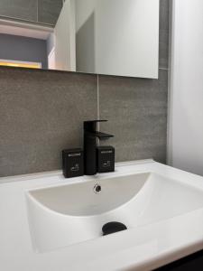 a white sink in a bathroom with a mirror at Le Genev Altitude - Studio Lumineux - Vue Montagne in Collonges-sous-Salève