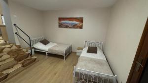 a room with two beds and a stair case at Apartament 11 Słoneczna in Ełk