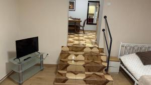 a room with a staircase with a television and a table at Apartament 11 Słoneczna in Ełk