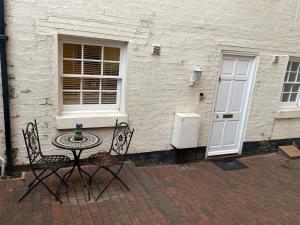 a table and two chairs in front of a building at Cosy Townhouse in Central Leamington with parking in Leamington Spa +11 photos