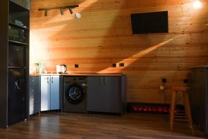 a kitchen with a washing machine in a room with wooden walls at Cottage TKESHI in Godogani