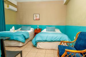 a room with two beds and a chair in it at Mirador Hotel in Corozal +32 photos