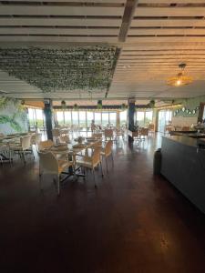a dining room with tables and chairs and windows at Mtunzini Rustic Retreat in Mtunzini